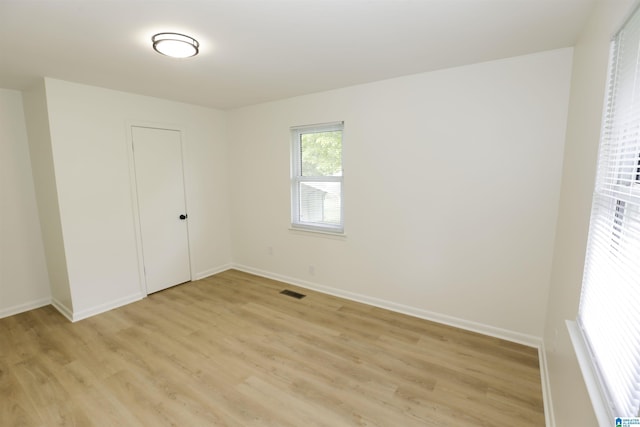 unfurnished bedroom featuring light wood-style floors, baseboards, and visible vents