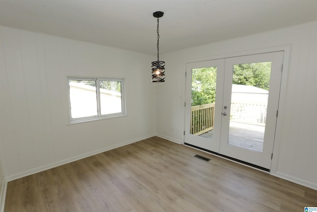 unfurnished dining area featuring visible vents, a healthy amount of sunlight, french doors, and light wood finished floors
