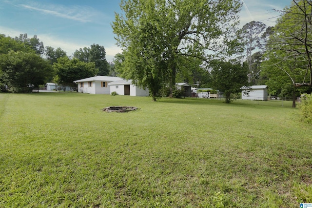 view of yard featuring fence and an outdoor fire pit