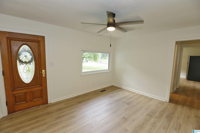 entrance foyer with ceiling fan, visible vents, baseboards, and light wood-type flooring