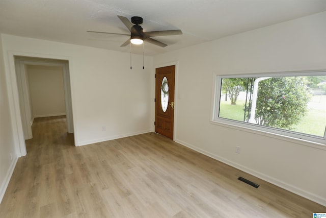 entrance foyer with baseboards, ceiling fan, visible vents, and light wood-style flooring