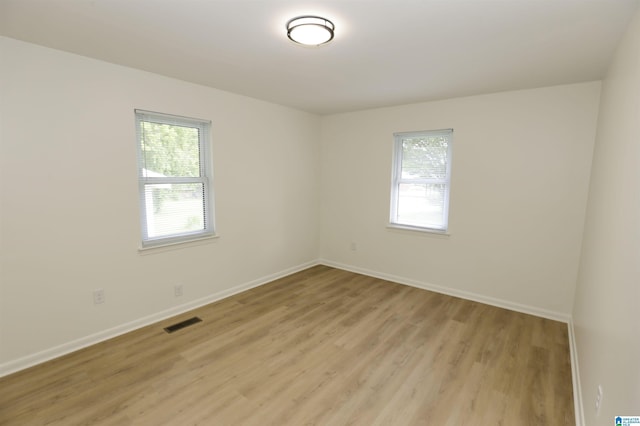 empty room with baseboards, light wood-style flooring, and visible vents