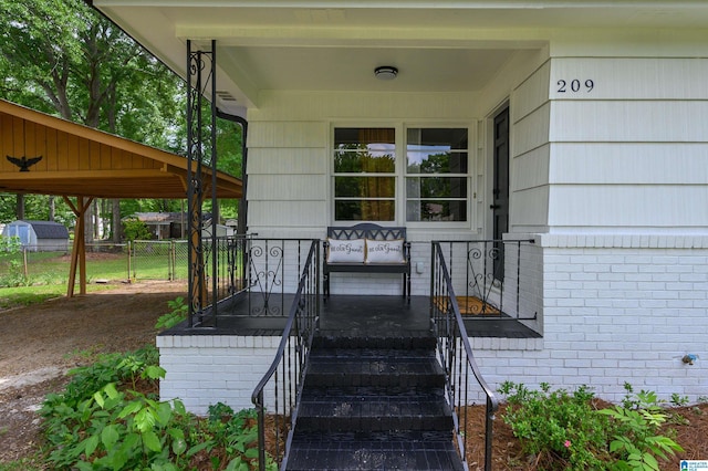 209 Nabors Ave, Hueytown, AL 35023 - property entrance featuring a porch, brick siding, and fence
