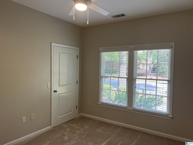 unfurnished room with visible vents, baseboards, ceiling fan, and carpet floors