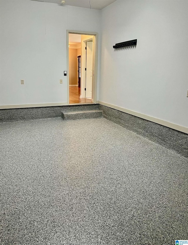 spare room featuring baseboards and speckled floor