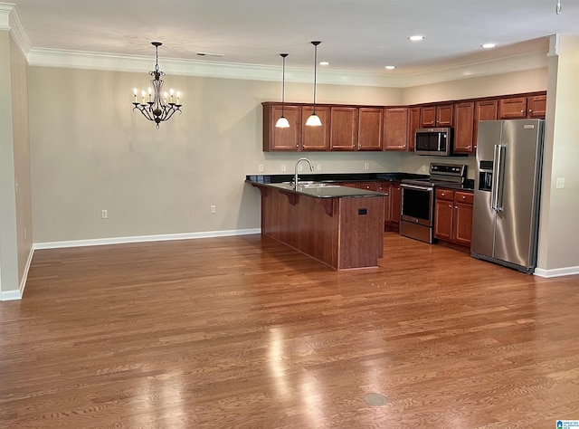 kitchen featuring a breakfast bar area, dark countertops, a sink, a peninsula, and stainless steel appliances