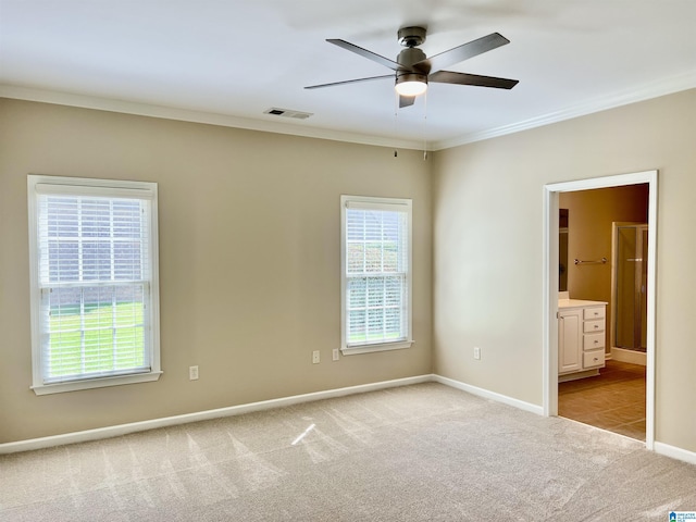 empty room with a ceiling fan, visible vents, baseboards, ornamental molding, and light carpet