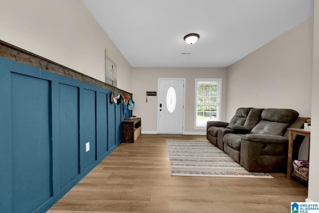 living room with light wood-type flooring, baseboards, and visible vents