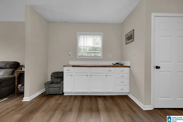 interior space with baseboards and wood finished floors
