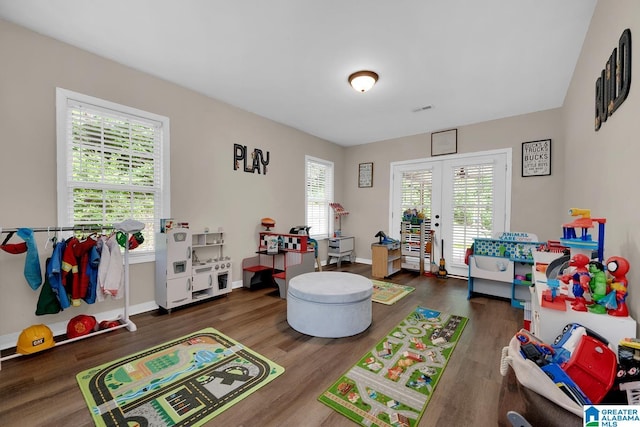 playroom featuring baseboards, french doors, visible vents, and wood finished floors