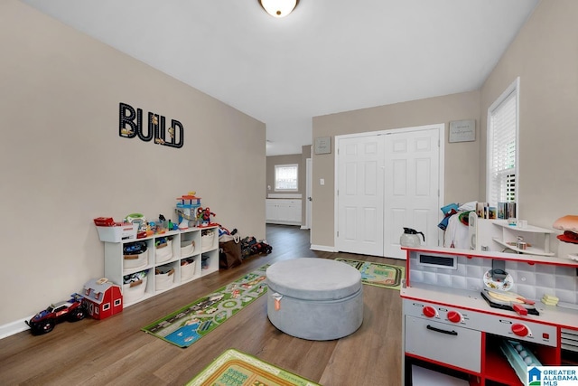 game room with baseboards and wood finished floors