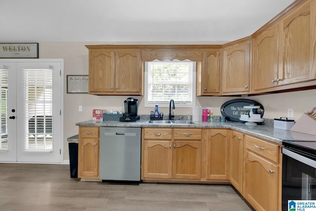 kitchen featuring light wood-style floors, a sink, dishwasher, and range with electric cooktop