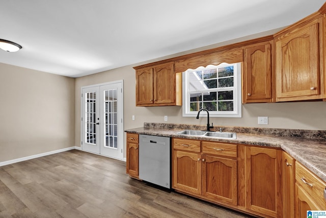 kitchen with french doors, brown cabinets, dishwasher, a sink, and light wood-style floors
