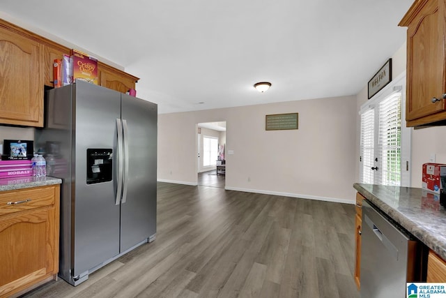 kitchen featuring stainless steel appliances, baseboards, and light wood-type flooring