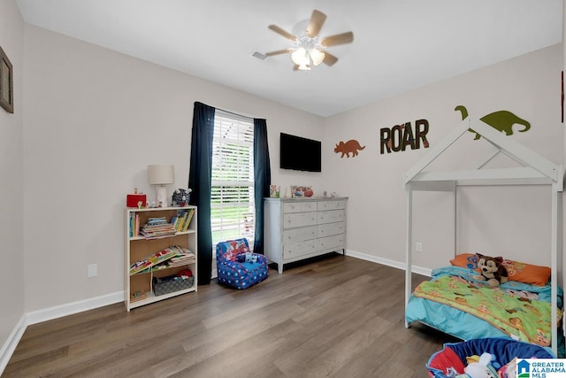 bedroom featuring visible vents, baseboards, ceiling fan, and wood finished floors