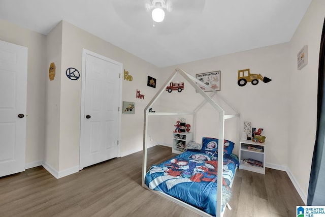 bedroom with baseboards, ceiling fan, and wood finished floors