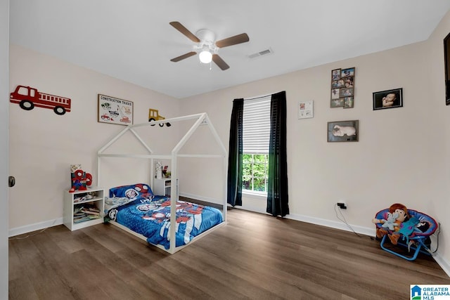 bedroom with baseboards, a ceiling fan, wood finished floors, and visible vents