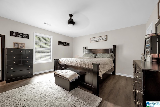 bedroom with a ceiling fan, baseboards, visible vents, and dark wood-type flooring