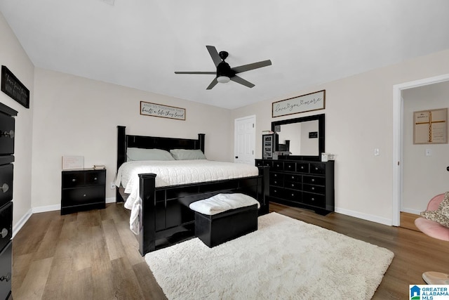 bedroom with a ceiling fan, baseboards, and wood finished floors