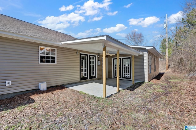 rear view of property featuring a patio, a ceiling fan, and a shingled roof