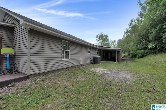 rear view of property with a lawn and central AC unit