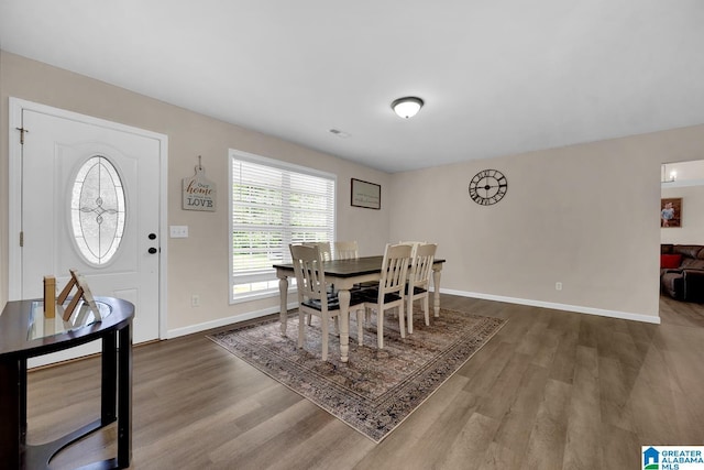dining space featuring baseboards and wood finished floors