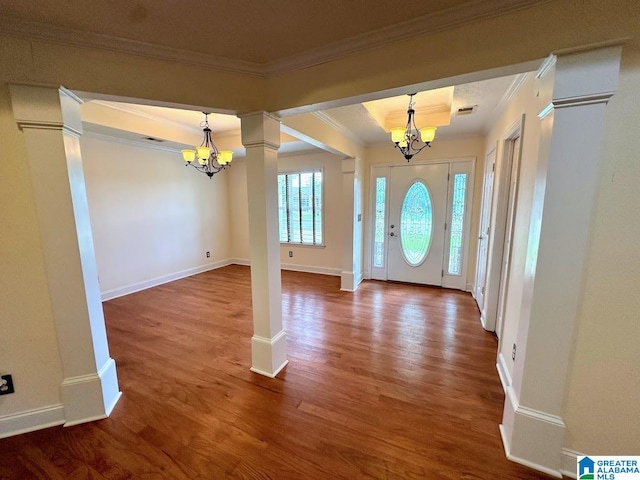 entrance foyer with crown molding, a raised ceiling, wood finished floors, and a chandelier