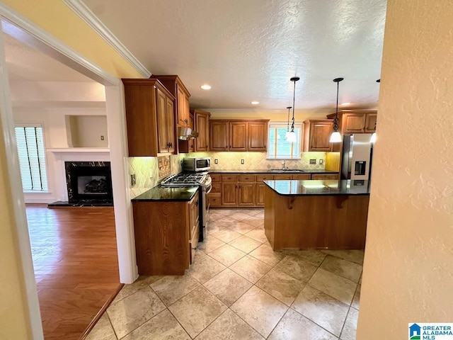 kitchen with a breakfast bar area, under cabinet range hood, dark countertops, and stainless steel appliances