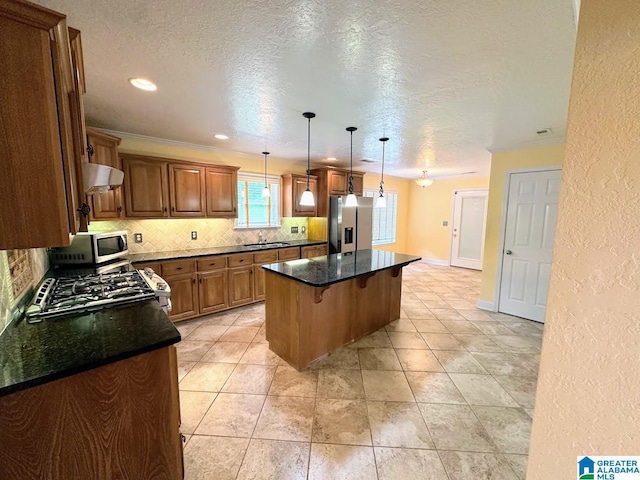 kitchen with a breakfast bar, stainless steel appliances, backsplash, under cabinet range hood, and a kitchen island