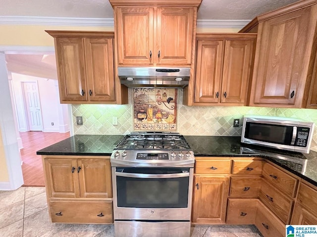 kitchen featuring decorative backsplash, crown molding, brown cabinets, under cabinet range hood, and stainless steel appliances