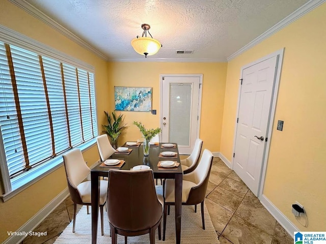 dining room featuring a textured ceiling, visible vents, light tile patterned floors, baseboards, and ornamental molding