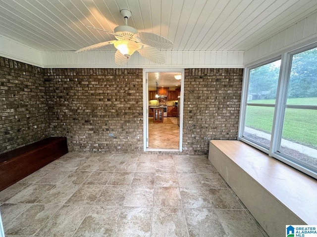 unfurnished sunroom featuring a ceiling fan