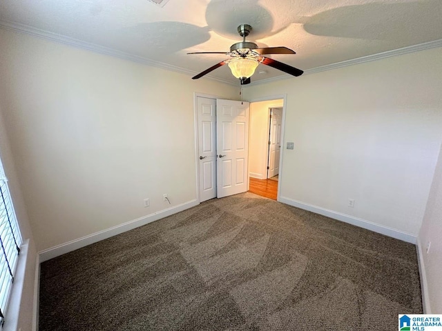 unfurnished bedroom featuring baseboards, ornamental molding, carpet, and a closet