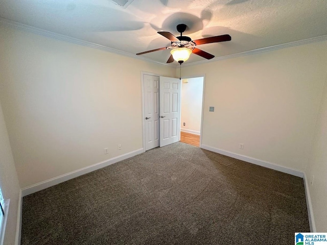 empty room with crown molding, carpet floors, ceiling fan, and baseboards