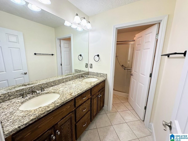 full bathroom featuring a sink, tile patterned floors, a shower stall, and double vanity