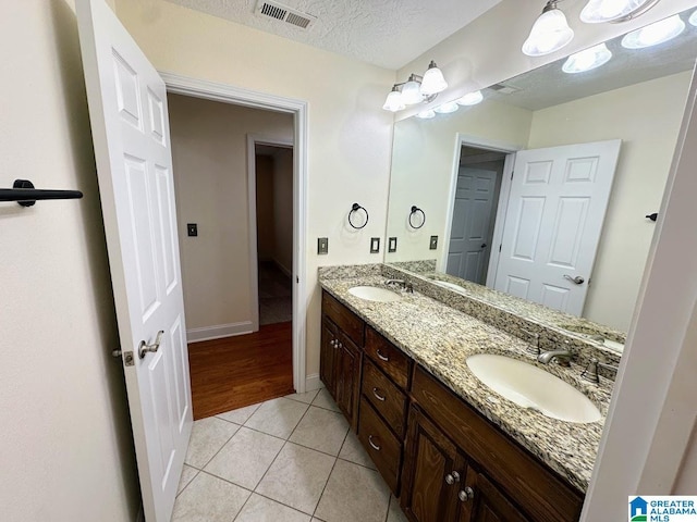 bathroom with visible vents, a sink, tile patterned flooring, and double vanity