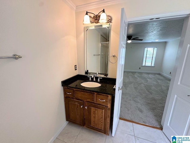 bathroom featuring tile patterned flooring, vanity, a ceiling fan, baseboards, and ornamental molding