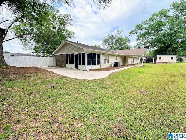 back of house featuring a lawn, central AC unit, a patio area, a sunroom, and fence