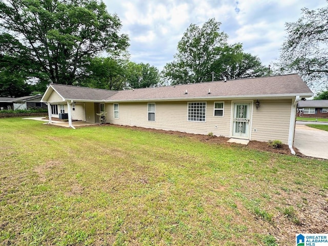 rear view of property with a lawn and driveway