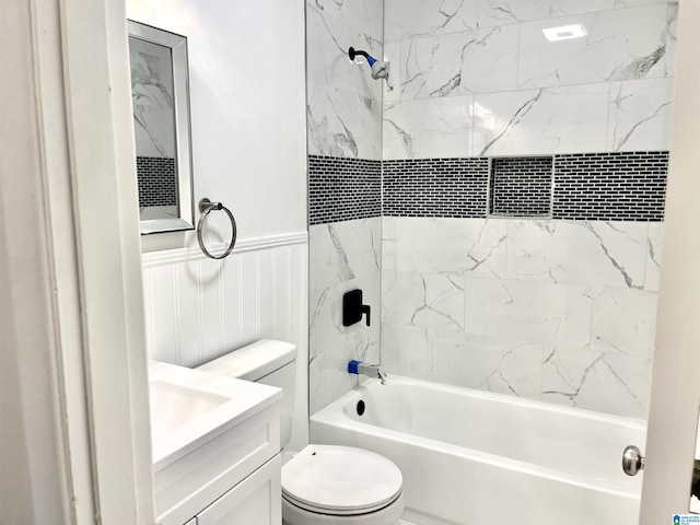 full bathroom featuring toilet, shower / bath combination, a wainscoted wall, and vanity