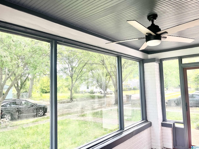 unfurnished sunroom with ceiling fan