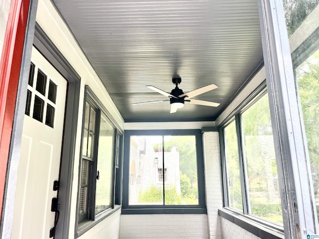 unfurnished sunroom with ceiling fan and plenty of natural light