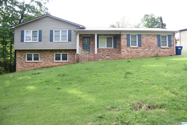 tri-level home with a front lawn and brick siding