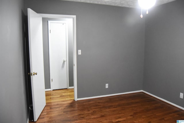 unfurnished room with baseboards and wood finished floors