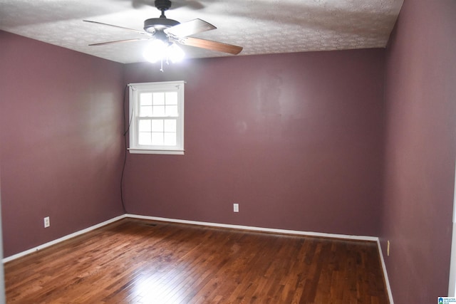 unfurnished room with wood-type flooring, a ceiling fan, baseboards, and a textured ceiling