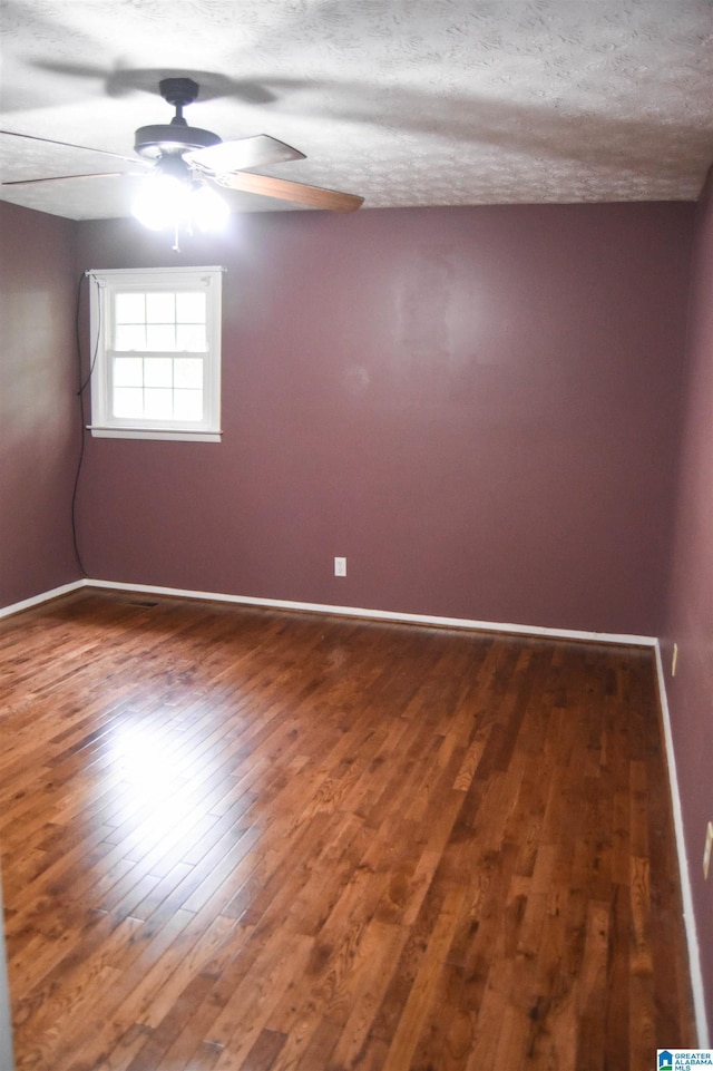 spare room featuring baseboards, ceiling fan, and wood finished floors