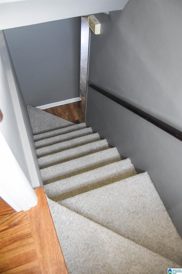 staircase featuring baseboards and wood finished floors