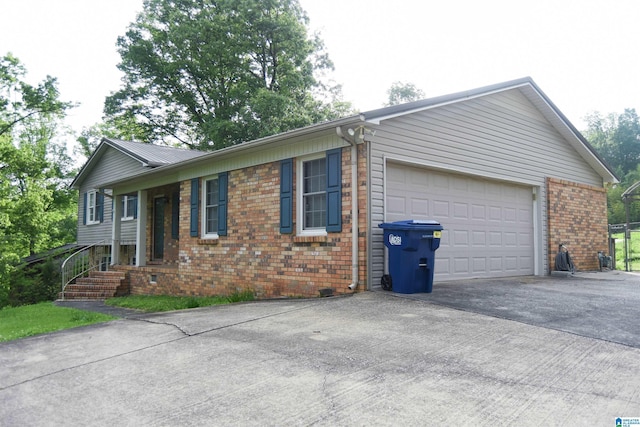 view of front facade with an attached garage, driveway, and brick siding