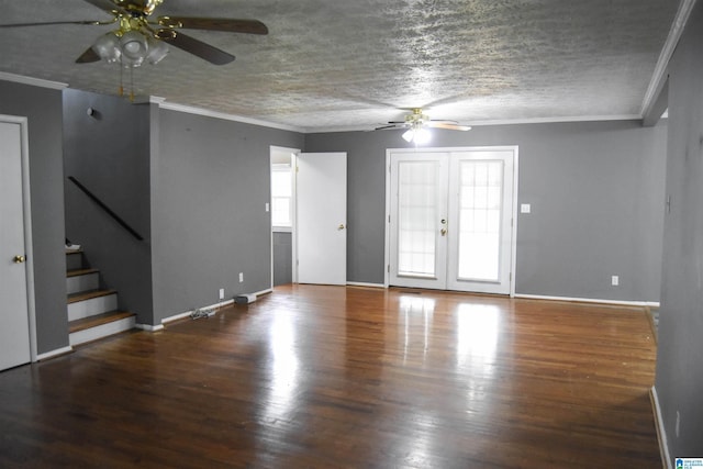 unfurnished living room featuring ceiling fan, crown molding, wood finished floors, stairway, and baseboards