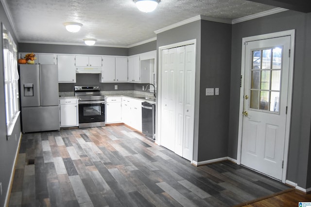 kitchen featuring appliances with stainless steel finishes, dark wood finished floors, a sink, light countertops, and under cabinet range hood